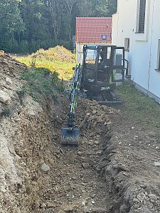 Výkopové práce a výkop základu pro opěrnou zeď ve svažitém terénu