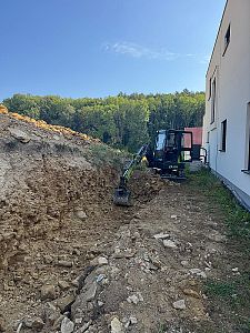 Výkopové práce a výkop základu pro opěrnou zeď ve svažitém terénu